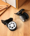4 Pcs Universal Suitcase Wheel Replacement Set Heavy Duty Luggage Casters Quiet Dual Row Design Black on wooden surface