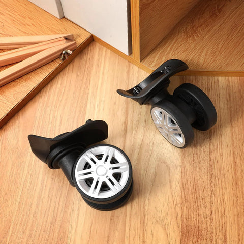 4 Pcs Universal Suitcase Wheel Replacement Set Heavy Duty Luggage Casters Quiet Dual Row Design Black on wooden surface