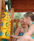 Children playing on Tic Tac Toe Spinner Activity Panel For Swing Sets, Backyard Play Accessory in yellow.