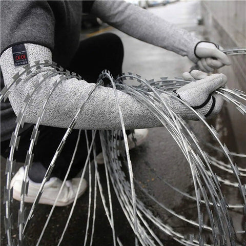 Person wearing 18 Inch Cut Resistant Sleeves Set For Kitchen And Outdoor Work Grade 5 Anti Cut Knit Arm Covers handling sharp wire.