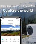 Smartphone displaying video feed next to Outdoor Security Camera Starter Bundle With Base Station And One Camera 1080P HD Wire Free Indoor Outdoor Night Vision Two Way Audio Weatherproof IP65 Works With Alexa And Google Assistant Camouflage Skin in a scenic mountain setting.