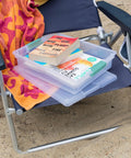 Stackable clear plastic storage bins with latching lids on a chair, used for organizing books, titled Six Pack Clip Boxes With Latching Lids.