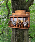 Wooden Squirrel Picnic Table Feeder With Four Seed Compartments And Seven Tier Bar Stools on a tree with three squirrels
