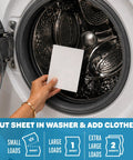 Person placing Heavy Duty Laundry Detergent Sheet Featuring 3x Stain Fighting Enzymes into washing machine for laundry.