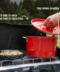 Two-Burner Propane Camp Stove With InstaStart Ignition And Wind Guards showing red pan and skillet on burners.