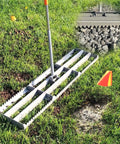 2-In-1 Lawn Leveling Rake With Flat And Serrated Sides, 48-Inch Heavy-Duty Stainless Steel, on grass with marking flag and rocks