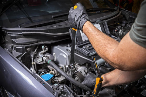 Mechanic using 15 Piece Ratcheting Serpentine Belt Tool Set for No Fuss Belt Removal And Installation on a car engine