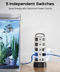26 In 1 Power Station With 20 Outlets And 6 USB Ports Including 2 USB C next to aquarium on wooden desk