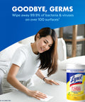 Woman using Lysol disinfectant wipes for all surfaces with antibacterial power, lemon-lime blossom scent, 80-count pack.