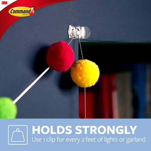 Clear Mini Light Clips For Damage-Free Decorating holding colorful pom-pom string on dark surface