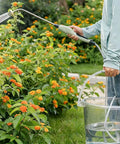 Person using Rechargeable Garden Sprayer Wand With 2000mAh Battery, Up To 5 Hours Of Nonstop Spraying, No Pump Needed on flowers