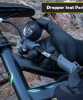 Cyclist using ShockPro MTB Shock Pump With 300 PSI High Pressure Gauge on mountain bike dropper seat post in rocky terrain.