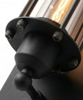Close-up of Industrial Outdoor Porch Wall Light Sconce with glass cylinder and steampunk cage, matte black, 18-inch vintage design.