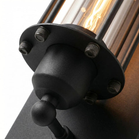 Close-up of Industrial Outdoor Porch Wall Light Sconce with glass cylinder and steampunk cage, matte black, 18-inch vintage design.