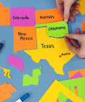 Hands assembling DIY U.S. Map Puzzle Kit With 112 Punch-Out Pieces, showing colorful state pieces fitting together.