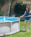 Woman using Deluxe Above Ground Pool Maintenance Kit With Vacuum For 800 GPH Flow Rate 110 Inch Telescoping Pole Wall Brush