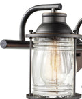 Close-up of oil rubbed bronze vanity fixture with seeded glass shade, part of All In One Bathroom Set With Oil Rubbed Bronze 3 Light Vanity Fixture, Towel Bar And Ring, Robe Hook And Toilet Paper Holder, Seeded Glass Shades, Modern Coastal Style.