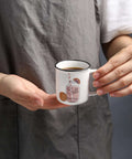 Person holding small ceramic espresso cup, possibly part of Four Pack Ceramic Demitasse Espresso Cups, 4.23 Oz Small Coffee Mugs for Espresso Machines and Home Coffee Makers, Microwave and Dishwasher Safe, Great for That Quick Caffeine Fix.
