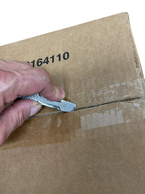 Close-up of Everyday Carry Mini Pry Bar Keychain With Screwdriver And Box Opener Heavy Duty Stainless Steel EDC Tool opening a package
