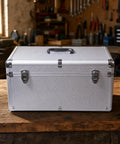 Silver Metal Tool Case With Ergo Grip Carrying Handle And Reinforced Corner Guards Built Different For Reliability During Harsh Field Repairs And Gear Storage With Multiple Secure Locking Clasps To Keep Your Wrenches Safe, shown from the front on a workbench.
