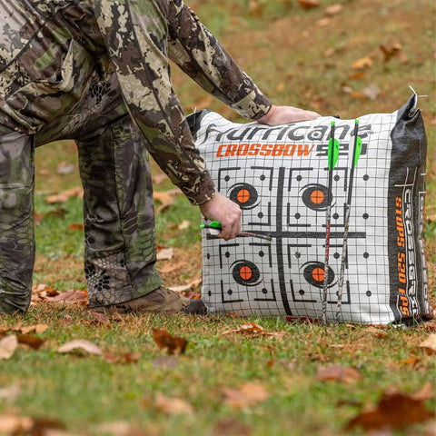 Hunter adjusts Dual Sided Crossbow Target Bag for high velocity practice up to 520 FPS, bright orange grid visible, compact 21 inch square.