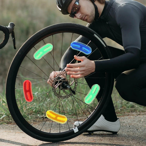 Cyclist attaching 20 Pack Bike Wheel Reflectors For Spokes, Compact Replaceable Reflective Signs, Lightweight Bicycle Safety Gear For Night Riding
