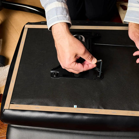 Person using Professional Grade Upholstery Tack Strip Half Inch Wide By Seventy Yards Long to secure fabric on chair.