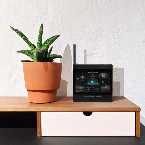 Atlas Pro Weather Station With Direct To Wi Fi HD Display Lightning Detection next to a potted plant on a desk.
