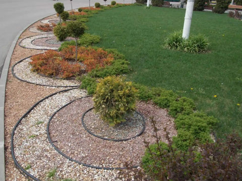 4 Inch HDPE Landscape Edging For Lawns And Flower Beds Flexible Garden Border System Black curved around plants on gravel