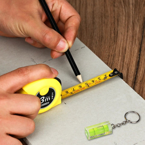 Person measuring with a tape measure and pencil from the 158 Piece Home Tool Set With Durable Chrome Finish Tools And Easy Carry Round Pouch.