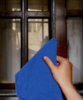 Hand cleaning window with blue Ultra Absorbent Cotton Shop Towels Pack Of 50 12 By 14 Inches Super Soft Rags For Home Garage And Auto Care Grime Busting Multipurpose Cleaning Towels For Industrial Use.