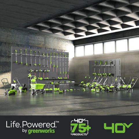 Wide array of 40V cordless garden tools displayed in a workshop, including mowers and hedge trimmers, by Greenworks.