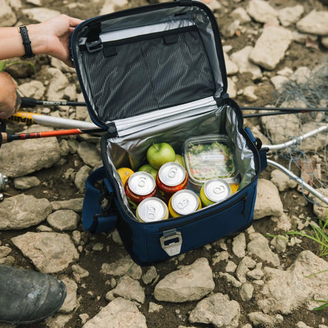 Open navy cooler with drinks and food, highlighting the 15 Can Everyday Soft Sided Go To Cooler For Lunch Beach Travel And Camping Insulated Portable Cooler For Men And Women Navy Keeps Drinks Cold All Day With Lightweight Build And Easy Carry Handle in use outdoors.