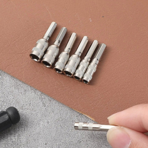7 Piece Hex Socket Adapter Set With H4 Shank Metric Micro Socket Sizes 2.5mm Through 5.5mm arranged on a surface with hand holding one adapter
