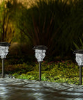 Bright Solar Pathway Lights 4 Pack Outdoor Waterproof Crackle Glass Aluminum Stake Lights For Garden Walkway Landscape Decor Solar Powered Easy Install, illuminating a garden path at night.