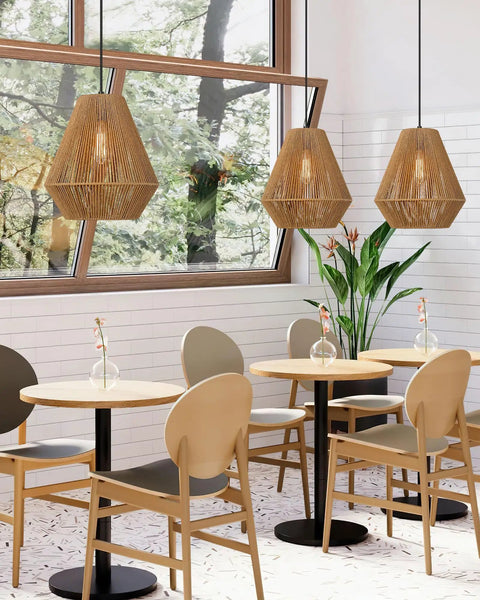 12 Inch Handwoven Rattan Pendant Light With Rustic Boho Vibe over dining tables in a modern minimalist cafe setting.