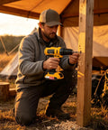 Man using Straight Up Heavy Duty Cordless Drill With Quick Change Chuck And Cushioned Hand Grip on wooden post outdoors.
