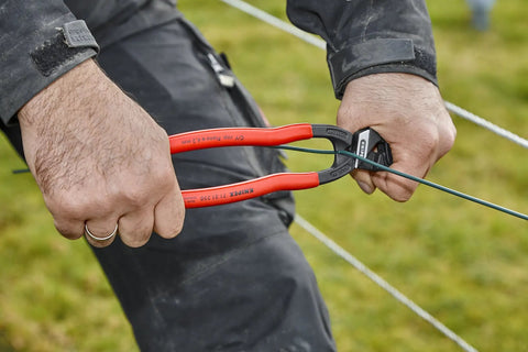 Hands using CoBolt Compact Bolt Cutter With Notched Blade For Heavy Duty Cutting Up To 0.170 Inch Diameter on wire outdoors