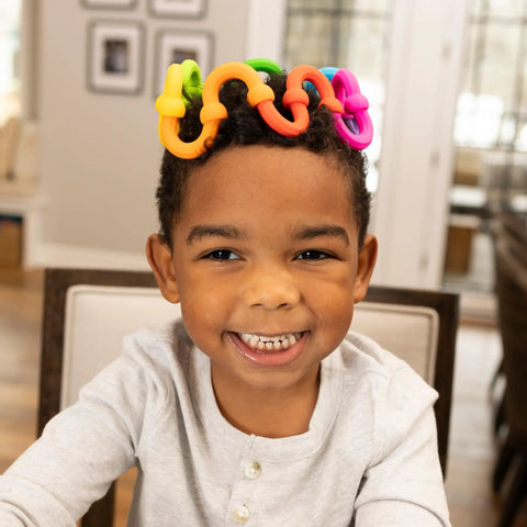 Plip Links Silicone Building Toys For Open Ended Creative Play A Fun Construction Set For Kids Aged 3 To 12 That Sparks STEM Skills Through Pattern Building And Preschooler Hands On Imagination, child wearing colorful silicone links