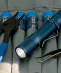 Quark LED Flashlight Pocket EDC With Clip, High CRI Beam, on tool case next to pliers and tweezers