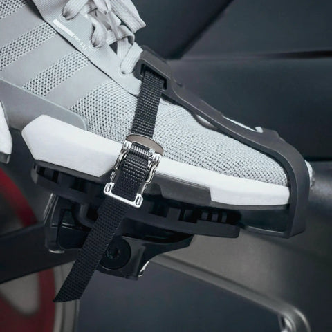 Shoe in toe clip cage adapter for Look Delta pedals, attached to bike, showing sneaker-friendly design for indoor cycling