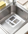 Hair Drain Stickers 100 Pcs Disposable Peel Stick applied in a stainless steel sink, catching hair and debris.
