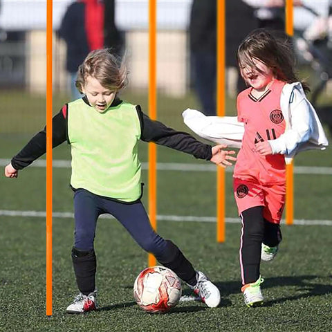 Children playing soccer using six 5ft adjustable agility poles for soccer basketball football dog and horse training outdoor orange set.