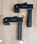 Two Pack Three Quarter Inch Aluminum Alloy Bench Dog Clamps For Woodworking positioned on a wooden workbench with holes.