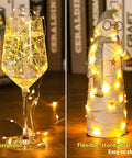 Six Pack Battery Operated Fairy Lights With 7 Foot Copper Wire And 20 LEDs Per String Warm White Firefly String Lights illuminating wine glass and snowman figurine indoors.