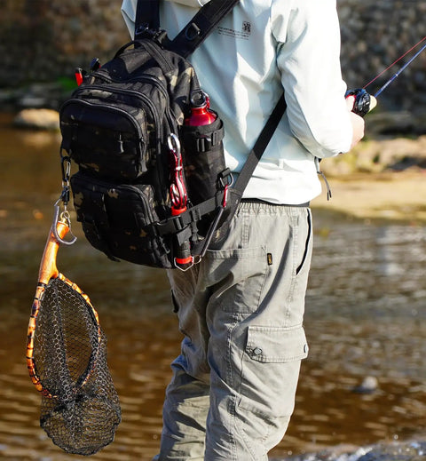 Person by river carrying Small Fishing Backpack With Rod Holder, Water Resistant Tackle Bag For Box Storage, Durable Go To Fishing Gear Pack