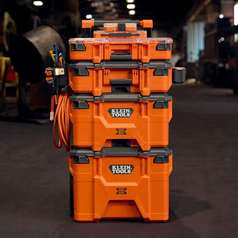Front view of stacked orange toolboxes in a workshop, featuring clear lids and secure latches.