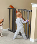 Child and dog near Extra Wide Baby Gate For Stairs And Doorways Fits 27 To 43 Inches With Walk Through 21 Inch Opening 30 Inch Tall Auto Close