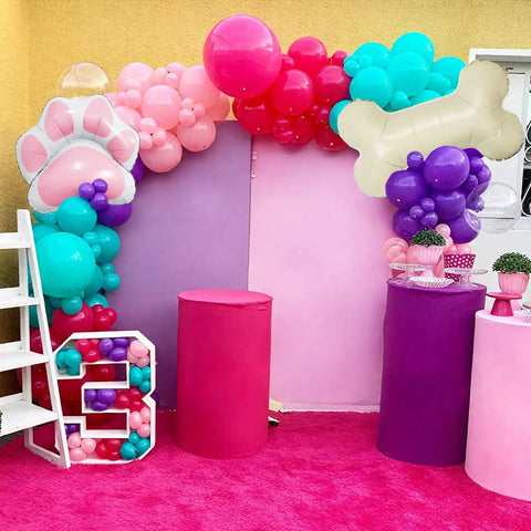 Doggo Approved Paw Print Party Balloon Kit With Pink Teal Purple Hot Pink Paw Print Balloons And Bone Foil Balloon For Girls Puppy Themed Birthday Or Baby Shower Decor in colorful setup with balloon arch and pedestals.