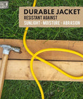 75 Ft Heavy Duty Outdoor Extension Cord 10 AWG Waterproof Yellow SJTW Power Cable on grass and wood with hammer nearby